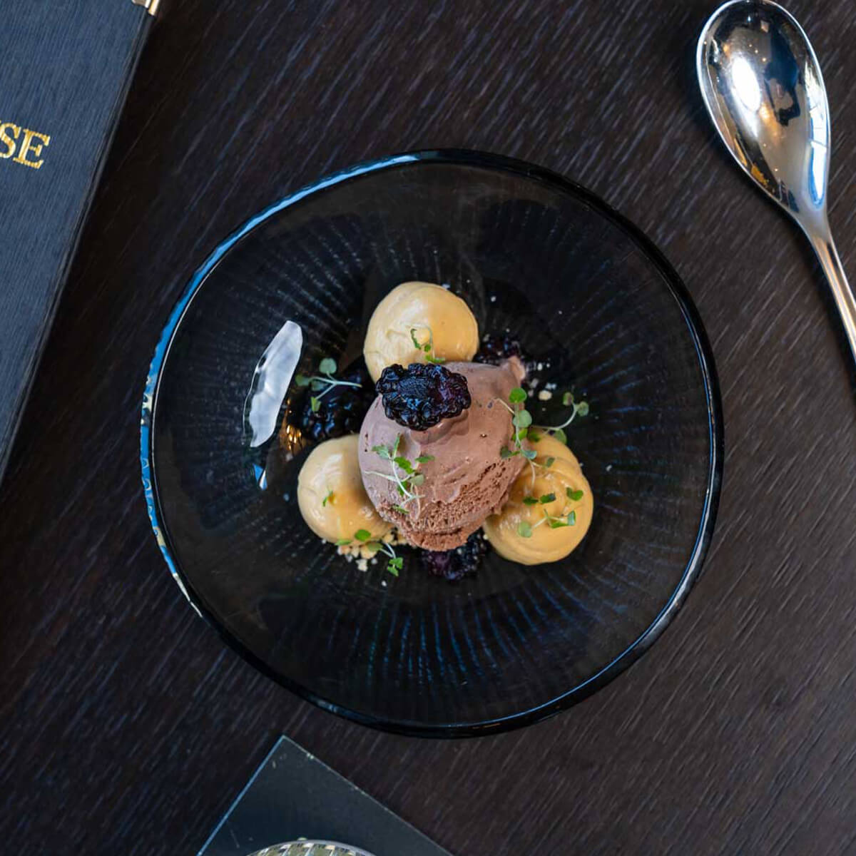 Chocolate parfait with blackberry and salted caramel in a smoked-glass bowl